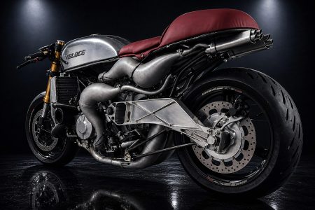 Veloce Aperion 2026 – Linkes Seitenprofil Studioaufnahme mit poliertem Tank und Veloce-Schriftzug, rotem Ledersitz, goldenen Öhlins-Gabeln, Gitterrohr-Schwinge und spiegelndem Boden