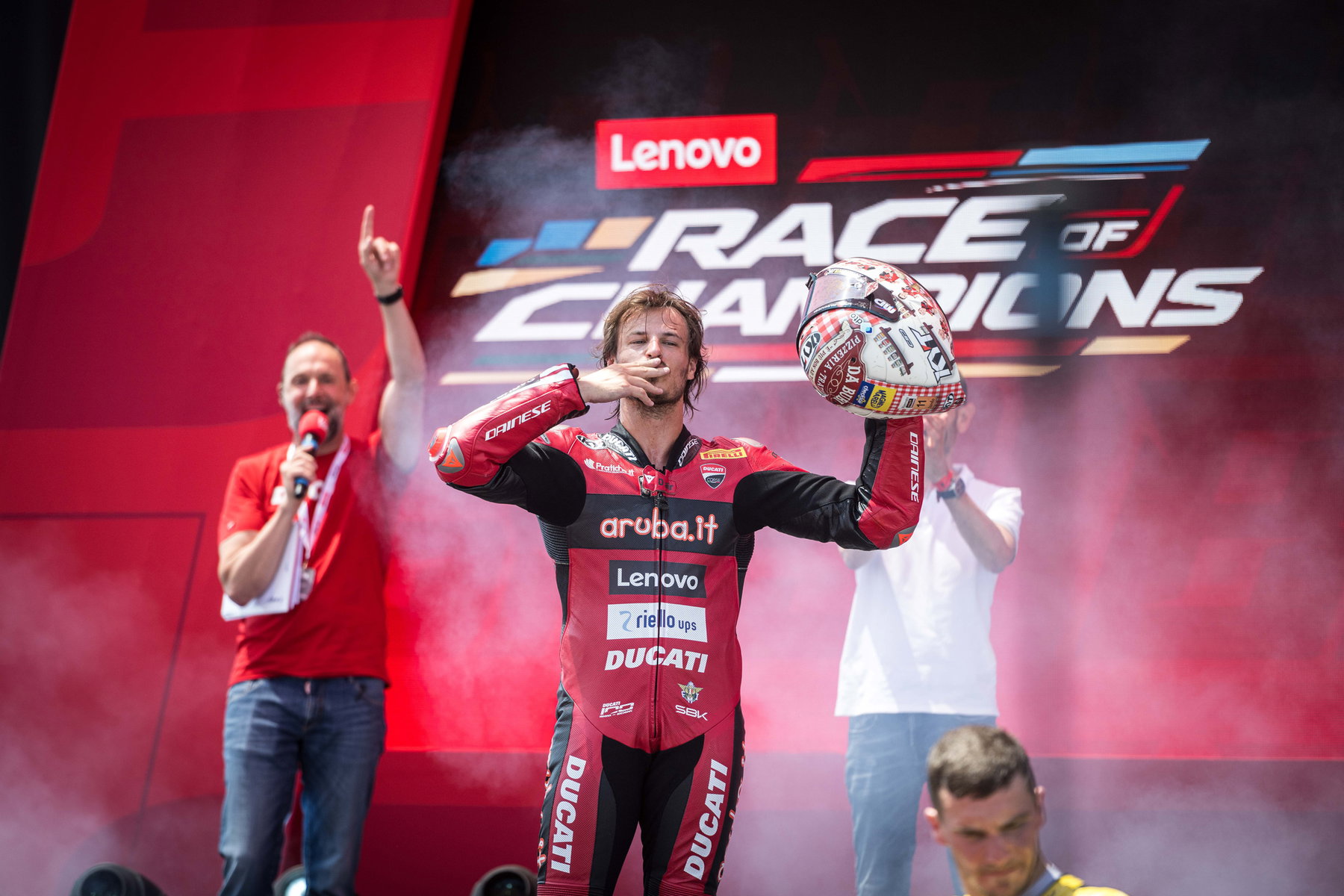 Nicolò Bulega mit Pokal im Interview vor dem Lenovo-Race-of-Champions-Banner bei der World Ducati Week 2026 in Misano