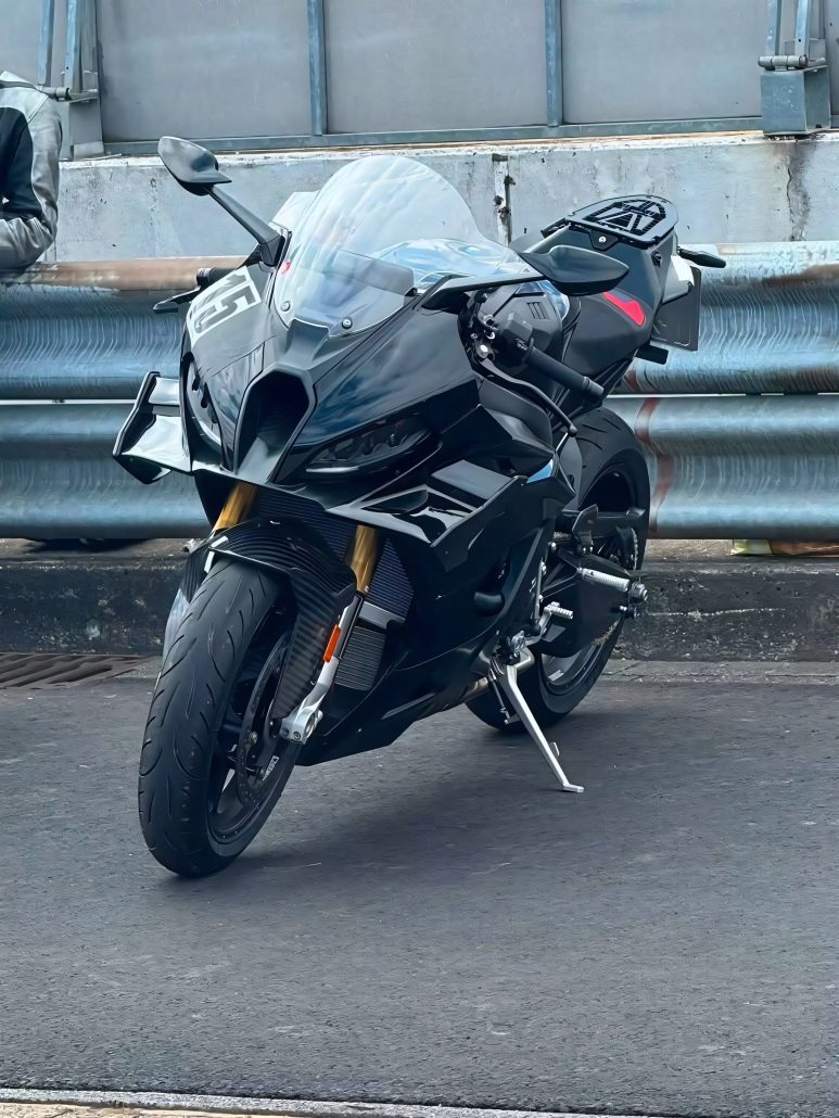 Neue BMW S 1000 RR: Erlkönig zeigt, was das Patentbild nicht verrät 6 BMW S 1000 RR 2028 Erlkönig – schwarzer Prototyp von vorn auf dem Seitenständer, mit Spiegeln, Windschild und profilierten Straßenreifen (Quelle: Instagram bt_moto_)
