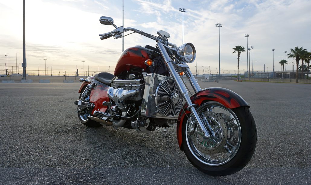 Boss Hoss Cruiser 2026: 8,1-Liter-V8 mit 600 PS im Einstiegsmodell 1 Boss Hoss Cruiser 2026 – Frontansicht des rot-schwarzen V8-Choppers mit Flammenlackierung auf einem Rennstrecken-Parkplatz