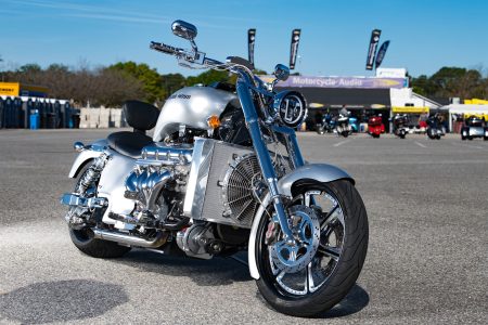 Boss Hoss Cruiser 2026 – Frontansicht eines silbernen V8-Choppers mit Boss-Hoss-Schriftzug auf dem Tank vor einem Motorradhändler