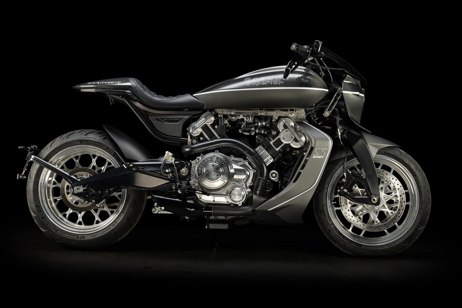 Brough Superior Dagger S: Was die neue Sportvariante wirklich ändert Brough Superior Dagger S 2026 – Seitenansicht rechts im Studio, Carbon-Karosserie in Schwarz mit Titanium-Akzenten, freiliegender V-Twin-Motor mit polierten Zylinderdeckeln, geschmiedete Aluminiumräder, Michelin Road Bereifung, S Sport Emblem