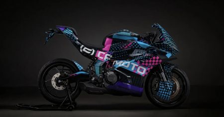 CFMoto 250SR-R 2026 – getarnter Prototyp mit bunter Tarnfolie, Halbprofilansicht im Studio (Aufmacherbild, echtes Foto, kein Renderbild)