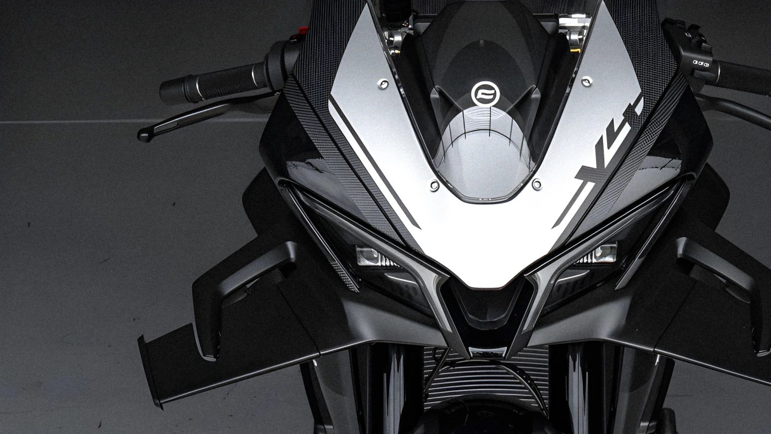 CFMoto V4SR-RR: Bewegliche Winglets reifen im Windkanal von Pininfarina CFMoto V4SR-RR Prototyp Detailansicht der Frontverkleidung mit weit ausgeklappten aktiven Aero-Winglets beidseitig des Scheinwerfers, Studioaufnahme