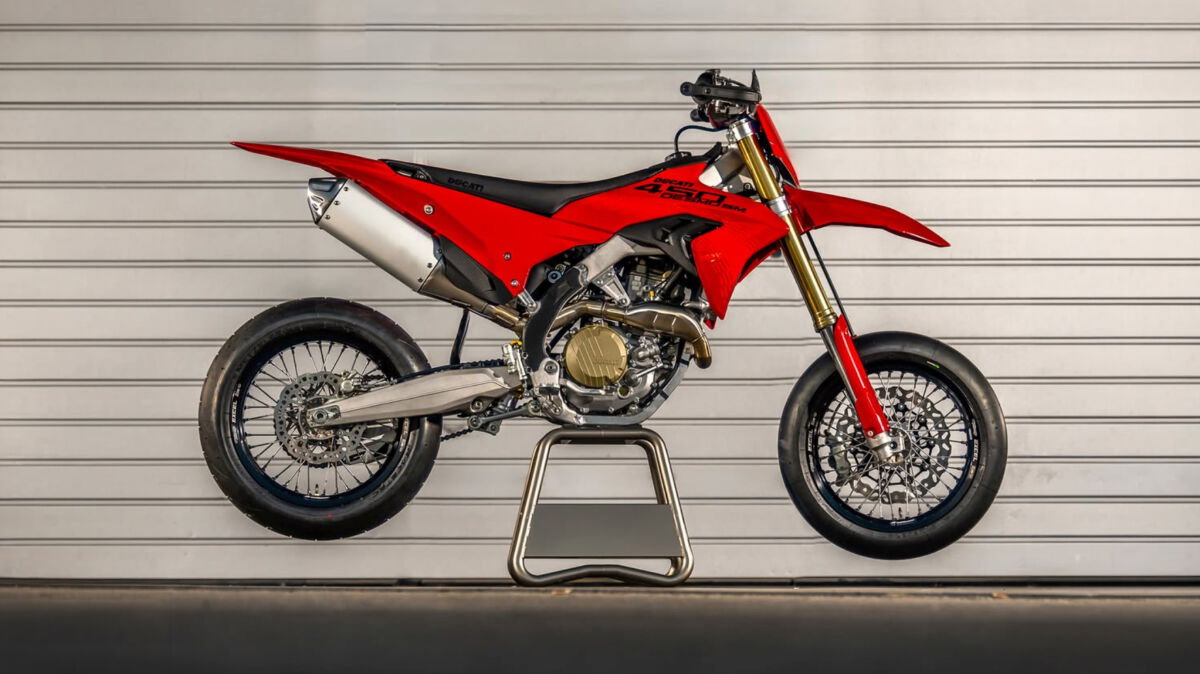 Ducati Desmo450 SM: Erste Renn-Supermoto der Marke feiert Premiere 3 Ducati Desmo450 SM 2026 – Seitenansicht vor weißem Rolltor in Studioumgebung mit sichtbarem Einzylinder-Desmo-Motor und Kettenantrieb