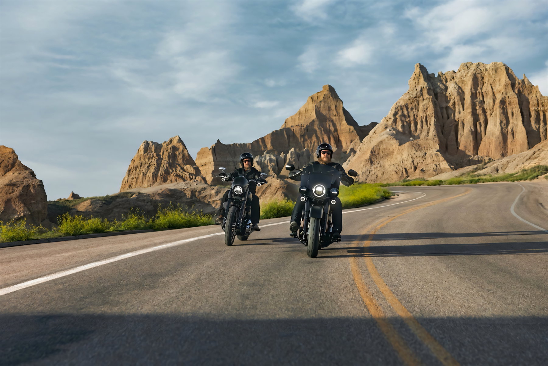 Harley-Davidson hebt Prognose an: Warum Europa das Problem bleibt 1 Harley-Davidson Deadwood – zwei Fahrer auf mattschwarzen Cruisern auf kurviger Landstraße durch die Felsformationen der Badlands
