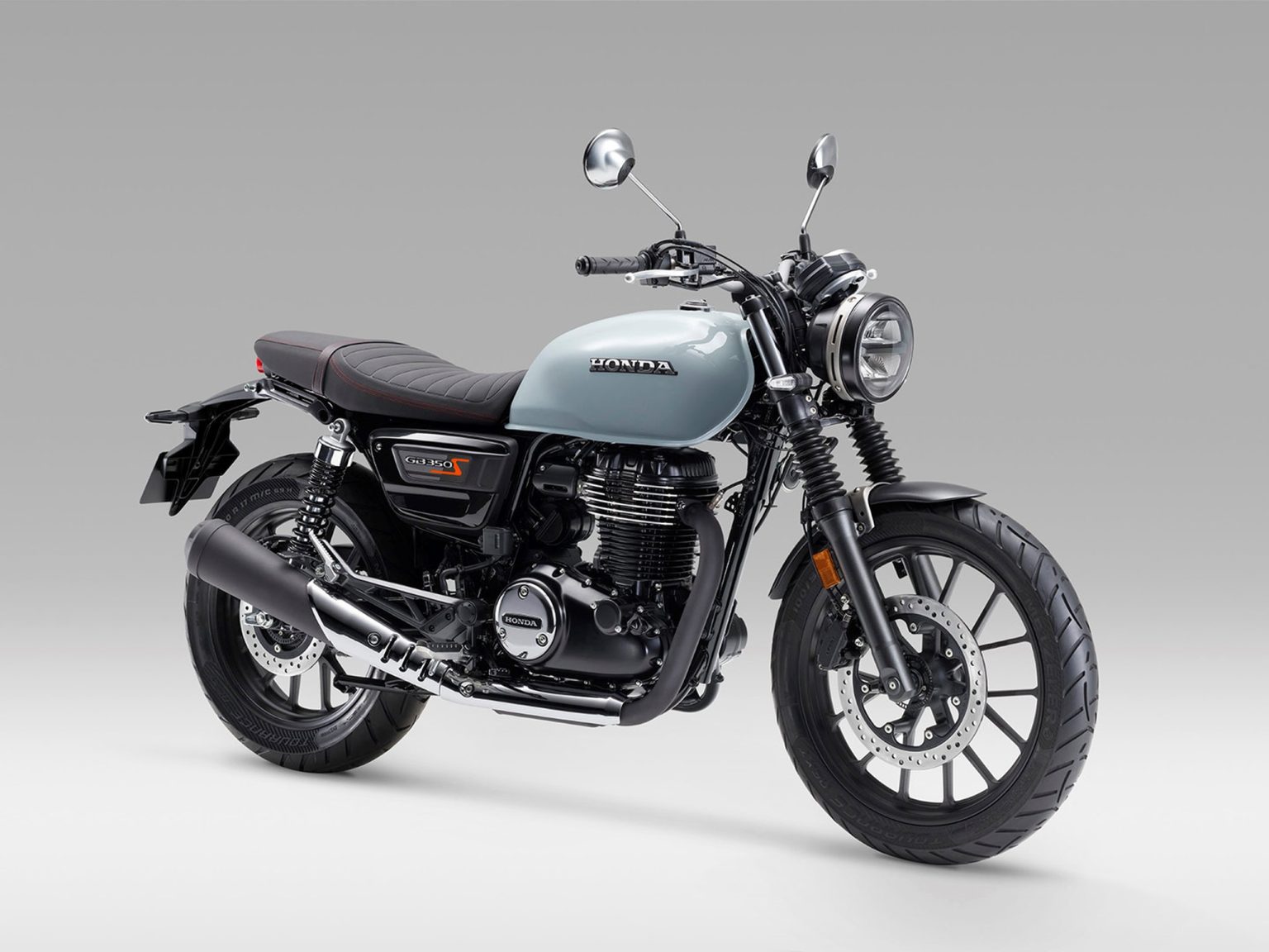 Honda CB 500 with 28 hp: What It Means for the GB 350 S in Europe Honda GB 350 S 2025 in Hellgrau – Dreiviertelansicht von vorne im Studio mit rundem Scheinwerfer und Speichenrädern
