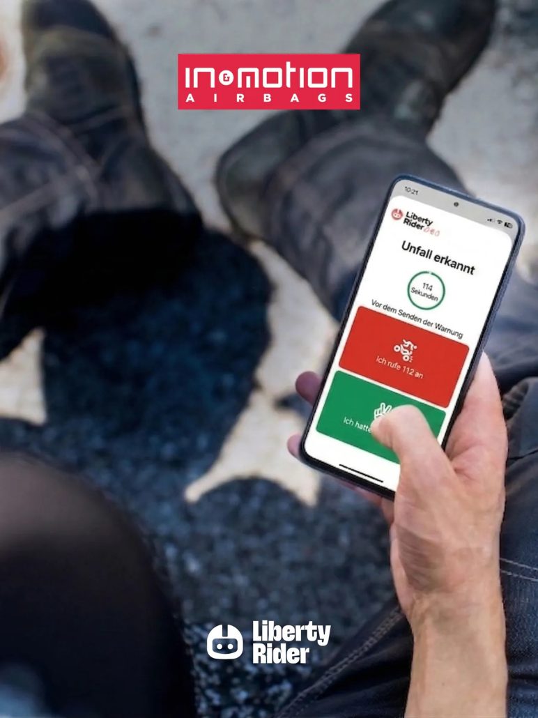 In&motion Emergency Call: Airbag ruft jetzt auch in Deutschland Hilfe 2 Nahaufnahme einer Hand, die ein Smartphone mit der Liberty-Rider-App hält, auf dem Display die Meldung 'Unfall erkannt' mit 114-Sekunden-Countdown und den Optionen '112 anrufen' oder 'Alles in Ordnung', im Hintergrund das In&motion-Airbags-Logo und die sitzende Person auf dem Boden