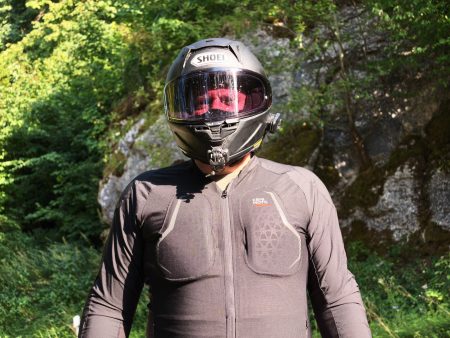 Kemimoto Motorradjacke 2026 – Nahaufnahme der Brustpartie mit zweigeteilten Brustprotektoren und Kemimoto-Logo, Fahrer vor Felswand