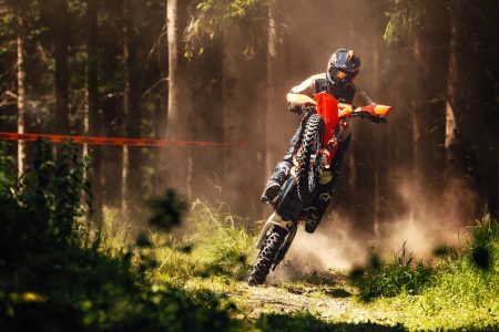 KTM 450 EXC-F 6DAYS 2027 – Enduro-Fahrer kommt frontal durch eine Staubwolke an einer Streckenmarkierung