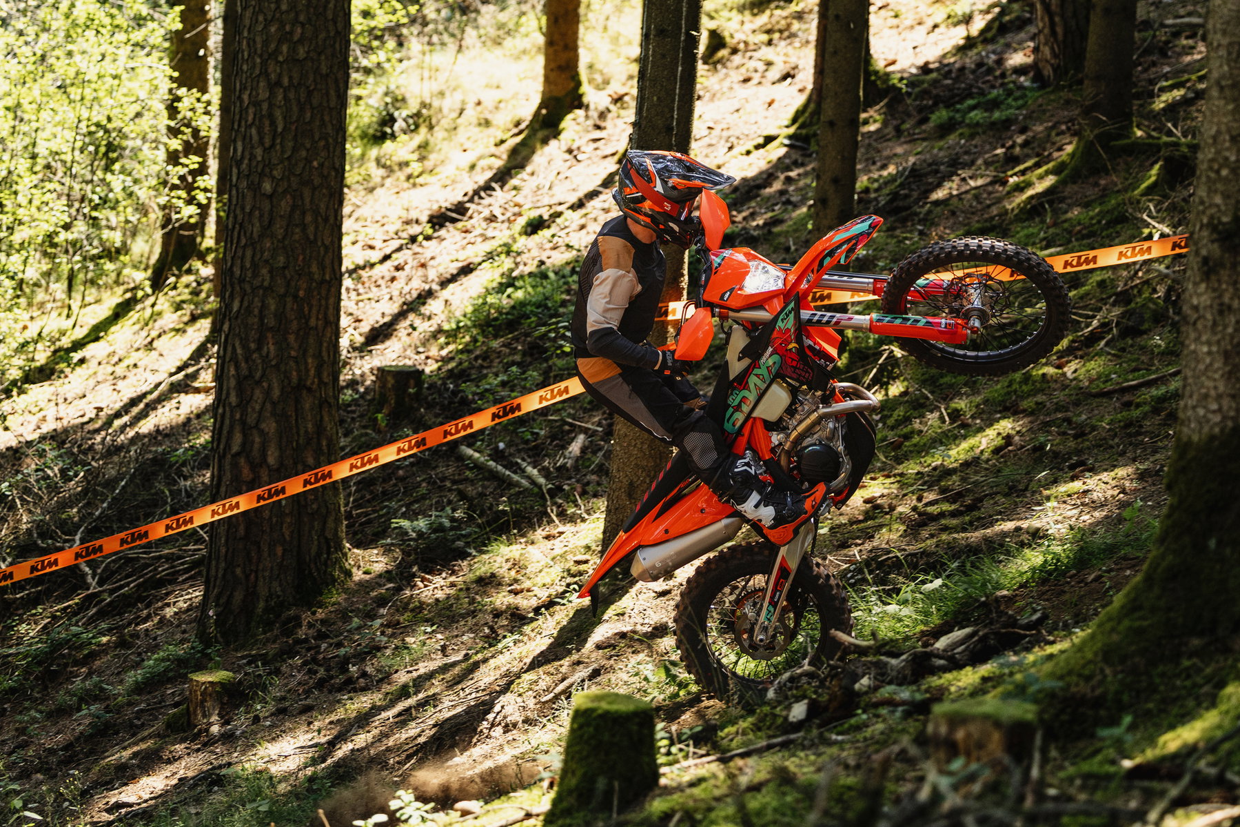 KTM EXC 6DAYS 2027: Special Edition for the 100th Six Days in Portugal 4 KTM 450 EXC-F 6DAYS 2027 – Enduro-Fahrer fährt einen steilen Waldhang an einer Streckenmarkierung hinab
