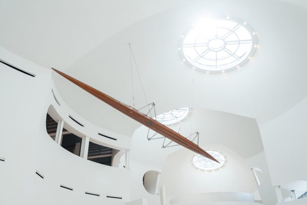 Moto Guzzi Opens New Factory: What's Changing in Mandello in 2026 2 Moto Guzzi World Days 2026 – interior view of the new museum with a floating historic record-breaking motorcycle under round skylights