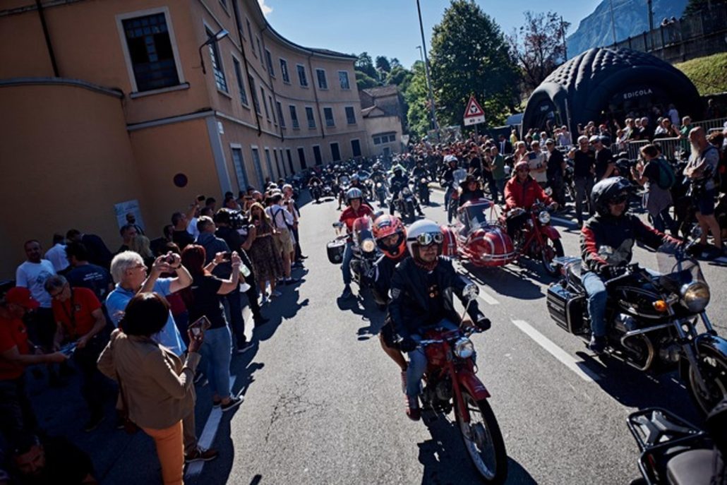 Moto Guzzi Opens New Factory: What's Changing in Mandello in 2026 4 Moto Guzzi World Days 2026 – parade of historic Moto Guzzi motorcycles through Mandello del Lario, lined with numerous spectators