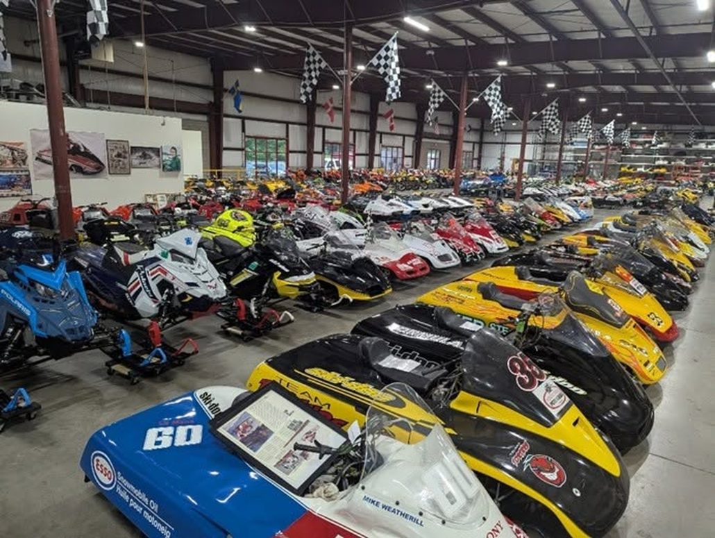 US Fraud Case: 600 Motorcycles and Snowmobiles Go Under the Hammer 2 View into a warehouse with historic Ski-Doo racing snowmobiles, a blue-and-white model with race number 60 in the foreground