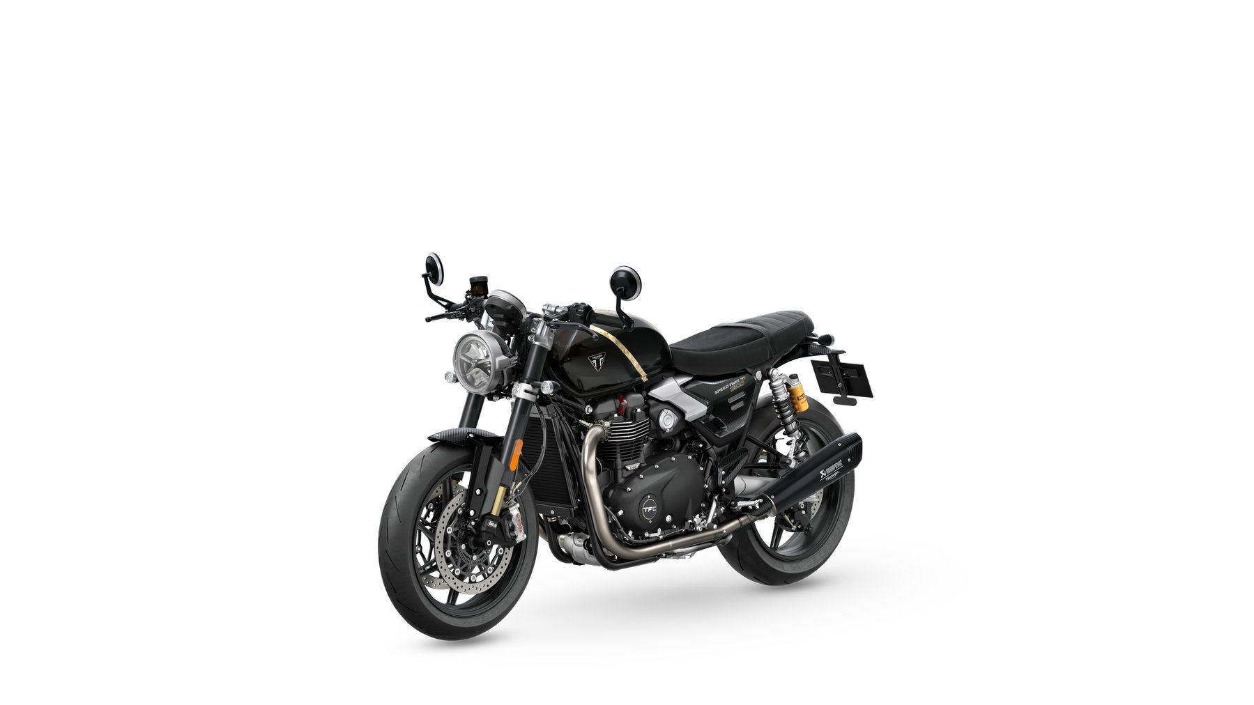 Triumph Speed Twin 1200 TFC: 750er-Sonderserie mit Öhlins und Akrapovič 3 Triumph Speed Twin 1200 TFC 2027 – linke Seite in schräger Frontansicht im Betonstudio, Obsidian Gold mit goldenem Zierstreifen und Akrapovič-Schalldämpfer