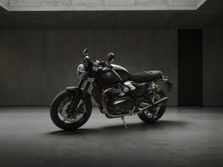 Triumph Speed Twin 1200 TFC 2027 – linke Frontperspektive im Betonstudio, Gesamtansicht in Obsidian Gold mit Öhlins-Gabel und Akrapovič-Schalldämpfer
