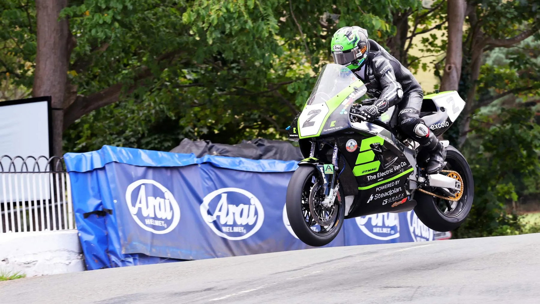 Classic TT: Dunlop Breaks the Anstey Record and Wins Twice in a Day 1 Mike Browne hebt mit der grün-schwarzen Electric-Van-Company-Kawasaki und der Startnummer 2 vor der Arai-Bande vom Asphalt ab – Formula One Classic TT, Isle of Man 2026