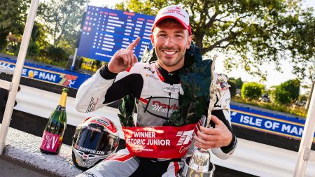 Paul Jordan feiert mit Lorbeerkranz, Pokal und Siegermütze seinen zweiten Erfolg in Folge vor der Isle-of-Man-Bande – Historic Junior Classic TT 2026