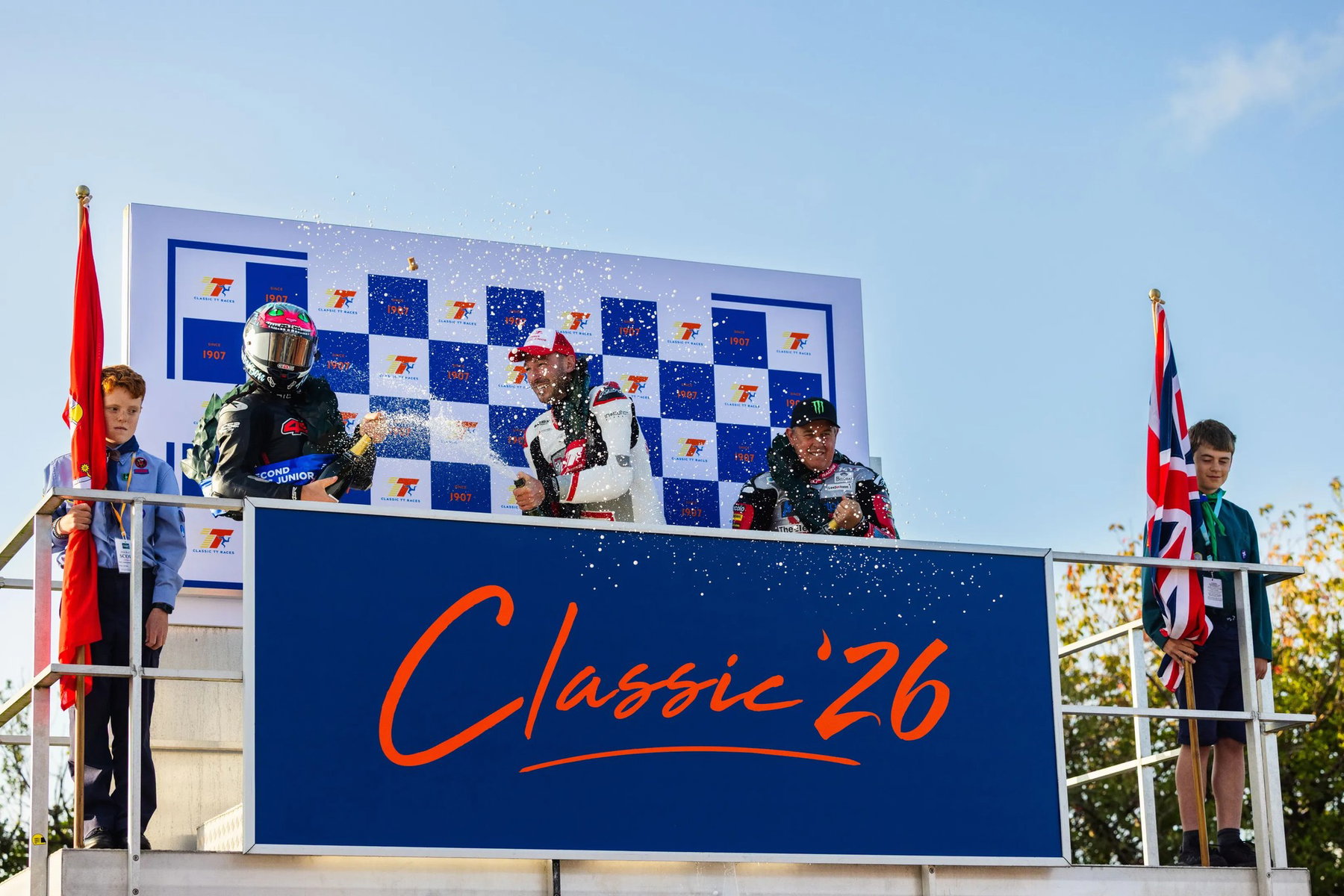 Dominic Herbertson, Paul Jordan und John McGuinness versprühen Champagner auf dem Classic-26-Podium – Historic Junior Classic TT, Isle of Man 2026