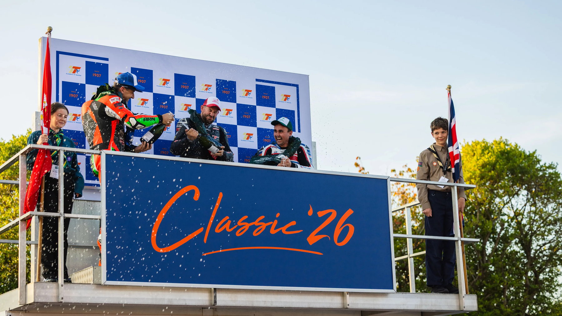 Rob Hodson wins the first Junior 600 Classic TT: Furber survives a fuel scare 4 Die drei Podiumsfahrer des Junior 600 Race feiern lachend mit Champagner auf dem Classic-26-Podium – Classic TT 2026, Isle of Man