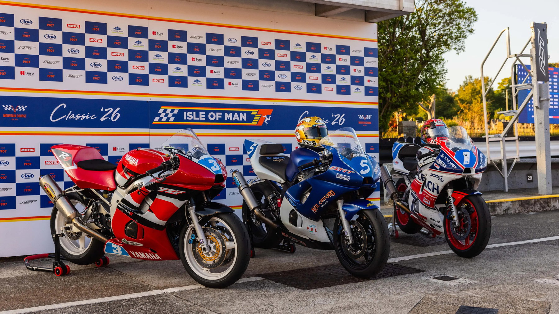 Rob Hodson wins the first Junior 600 Classic TT: Furber survives a fuel scare 3 Die drei Podiumsmaschinen des Junior 600 Race mit den Startnummern 3, 5 und 1 nebeneinander vor der Sponsorenwand – Classic TT 2026, Isle of Man