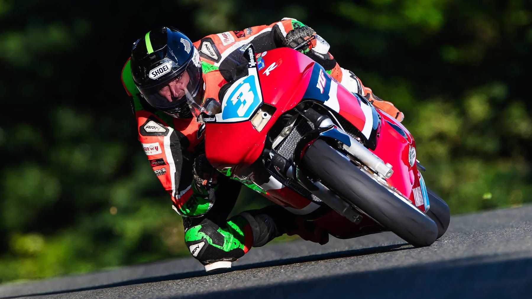 Rob Hodson wins the first Junior 600 Classic TT: Furber survives a fuel scare 2 Baz Furber in tiefer Schräglage auf der rot-blau-weißen Yamaha YZF mit Startnummer 3 vor dunklem Grün – Junior 600, Classic TT 2026, Isle of Man
