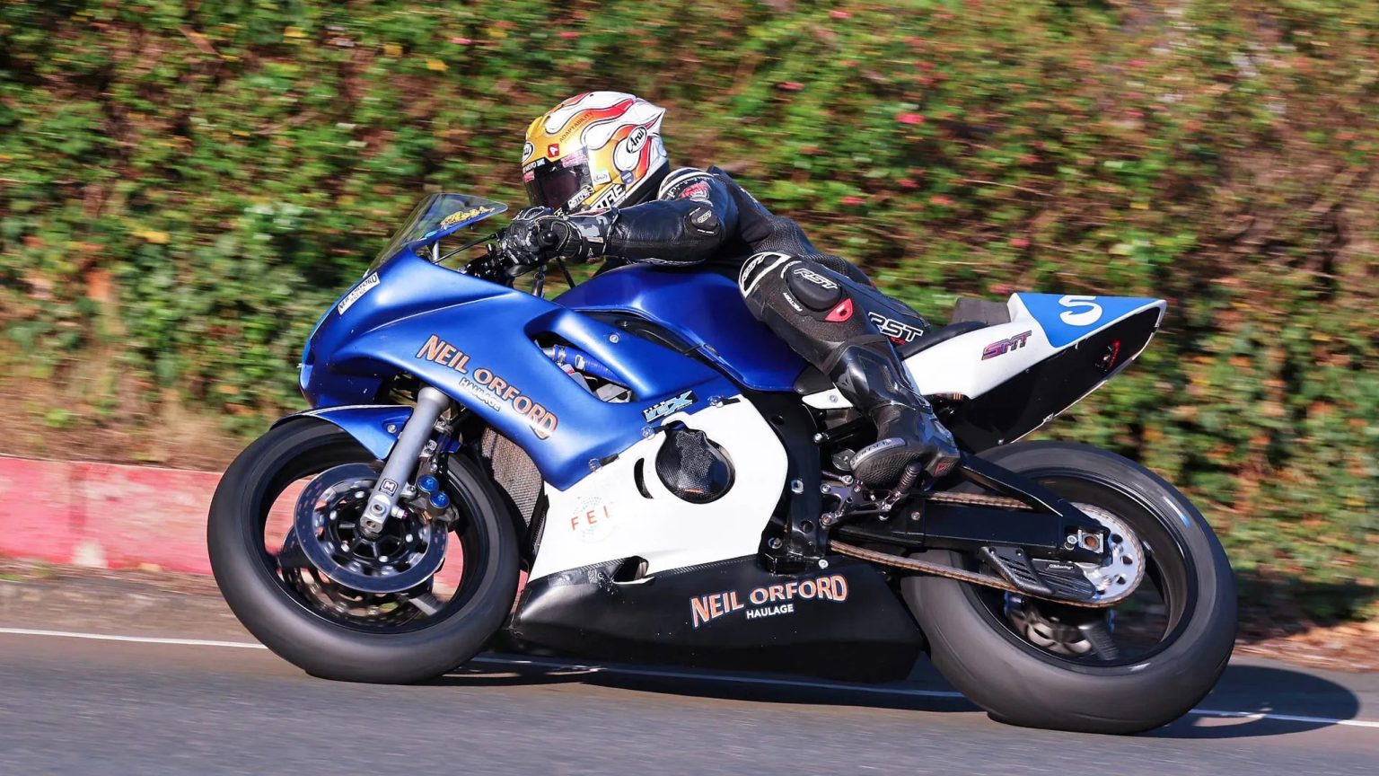 Rob Hodson wins the first Junior 600 Classic TT: Furber survives a fuel scare Rob Hodson im Mitzieher auf der blau-weißen SMT-600er mit Startnummer 5 an einer Hecke des Mountain Course – Junior 600, Classic TT 2026, Isle of Man