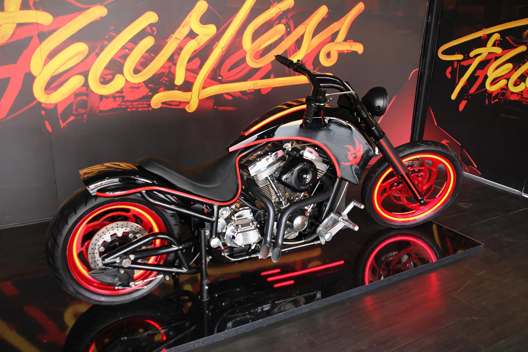 Sega spendet Dark Rider: Guintoli versteigert Sonic-Bike für Stiftung 7 Dark Rider Custombike auf spiegelnder Ausstellungsbühne vor großformatigem 'Fearless'-Wandbild, Seitenansicht mit rotem Streiflicht