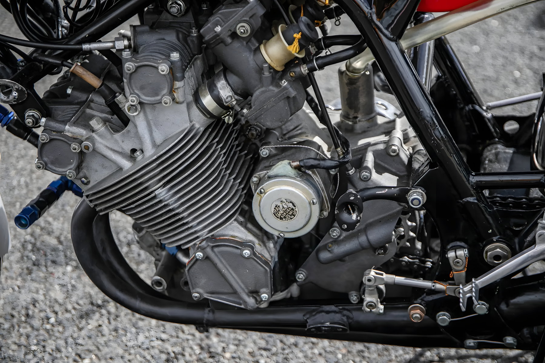 Hailwoods Honda RC173 kommt unter den Hammer: Rekordpreis in Sichtweite 5 Nahaufnahme des luftgekühlten Vierzylindermotors der Honda RC173 mit Kühlrippen, Vergasern und blauen Leitungsanschlüssen