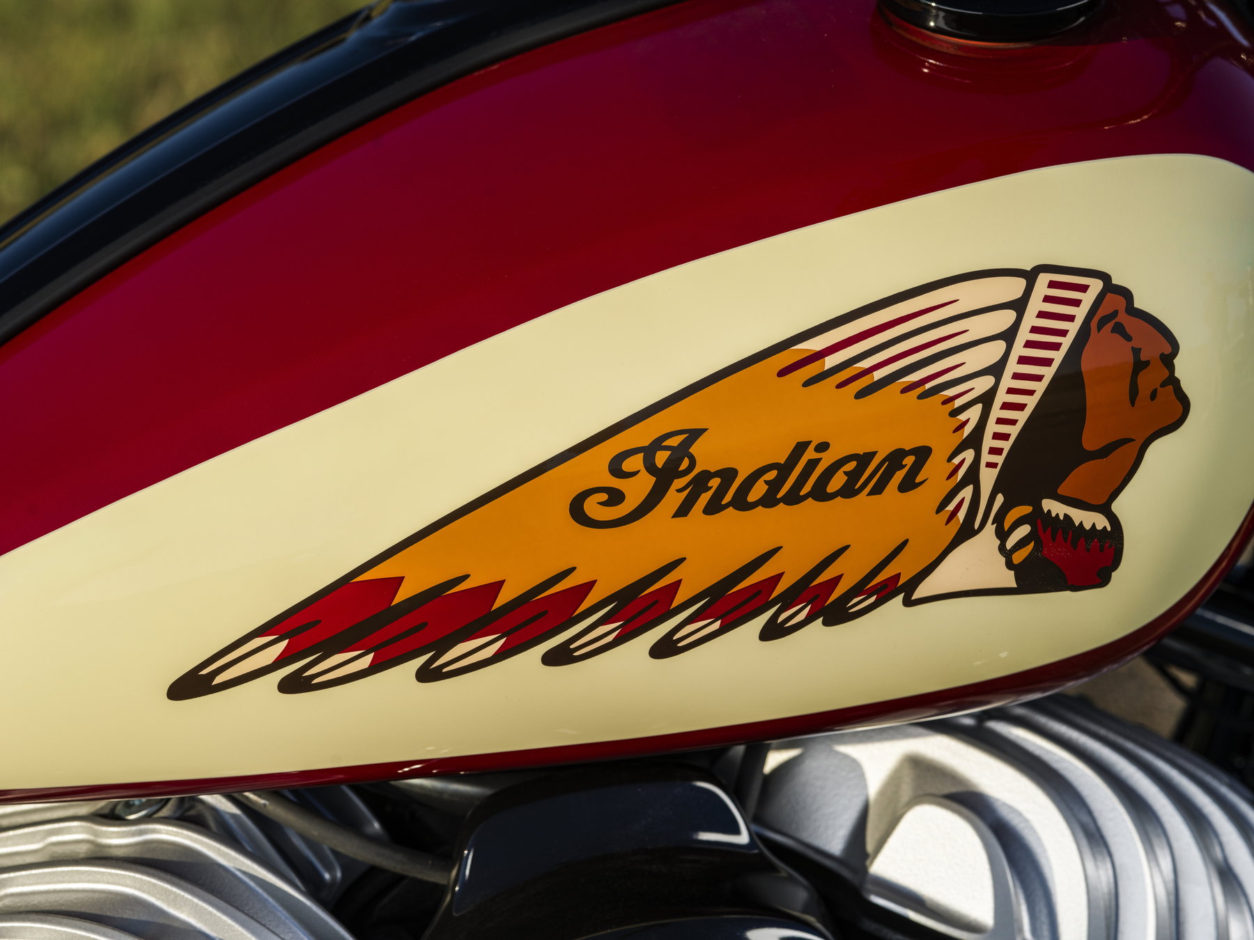 Detailaufnahme des Tanks mit mehrfarbigem Indian-Motorcycle-Headdress-Logo auf cremefarbenem Feld und rotem Lack