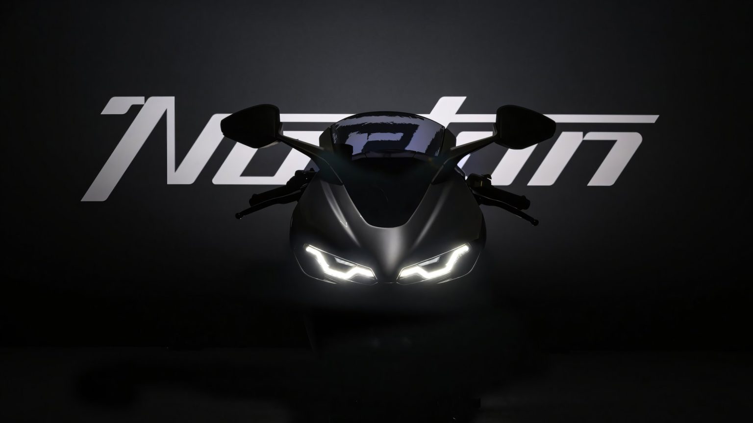 Norton Manx R gewinnt IDEA Award: Was hinter dem Designpreis steckt Norton Manx R (2026) – Frontansicht im abgedunkelten Studio mit beleuchtetem Norton-Schriftzug und LED-Scheinwerfern
