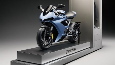 Norton Showroom-Konzept (2026) – weite Seitenansicht des gesamten Moduls mit Norton-Schriftzug auf der Bodenplattform und Merchandise-Kabinett am rechten Rand