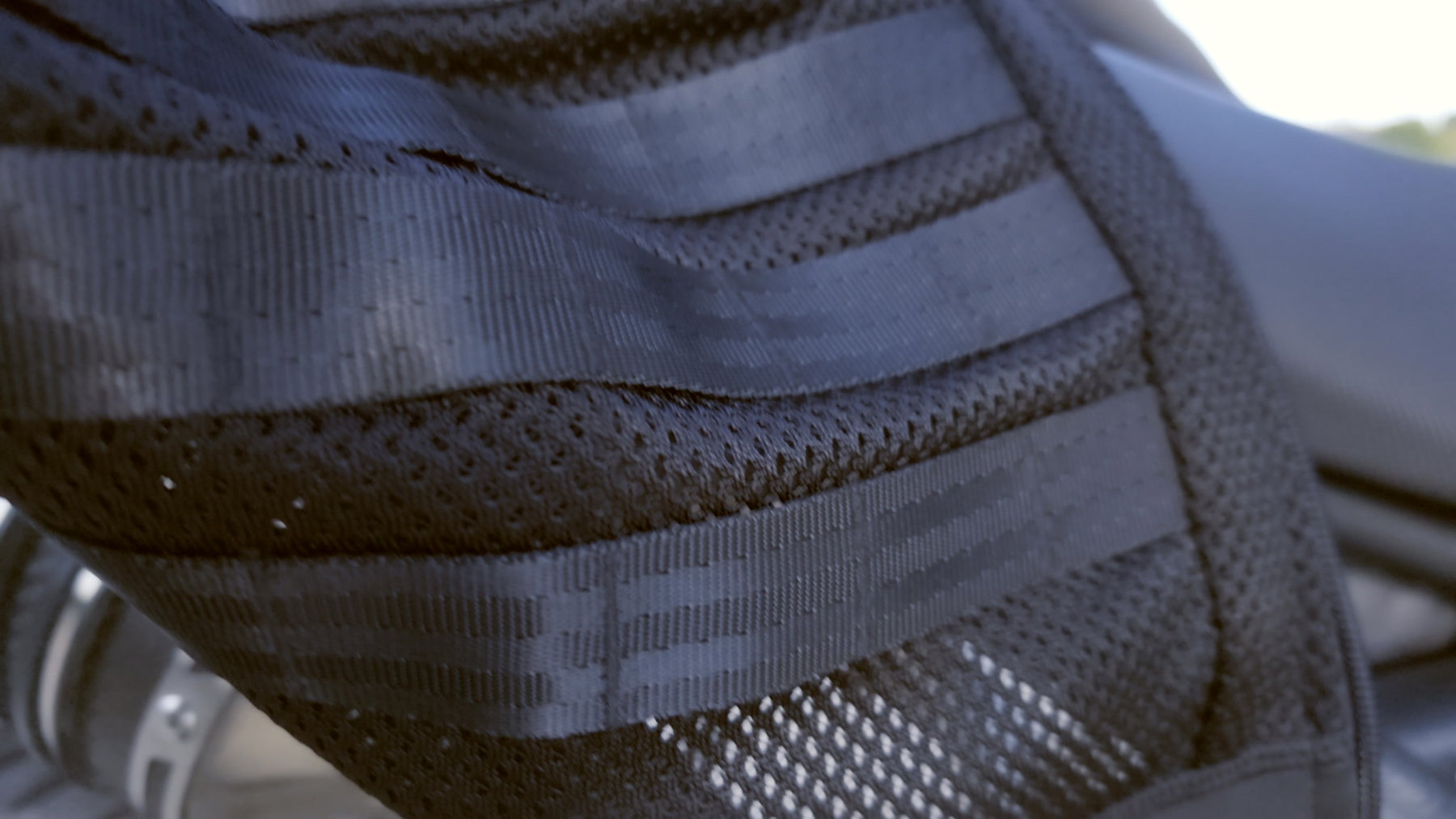 Pando Moto Commando UH und Skin UH 03: Schutzkleidung, die niemand sieht 3 Detailaufnahme der Pando Moto Commando UH – schwarze MOLLE-Befestigungsschlaufen auf dem Cordura-Netzgewebe am Rumpf der Jacke