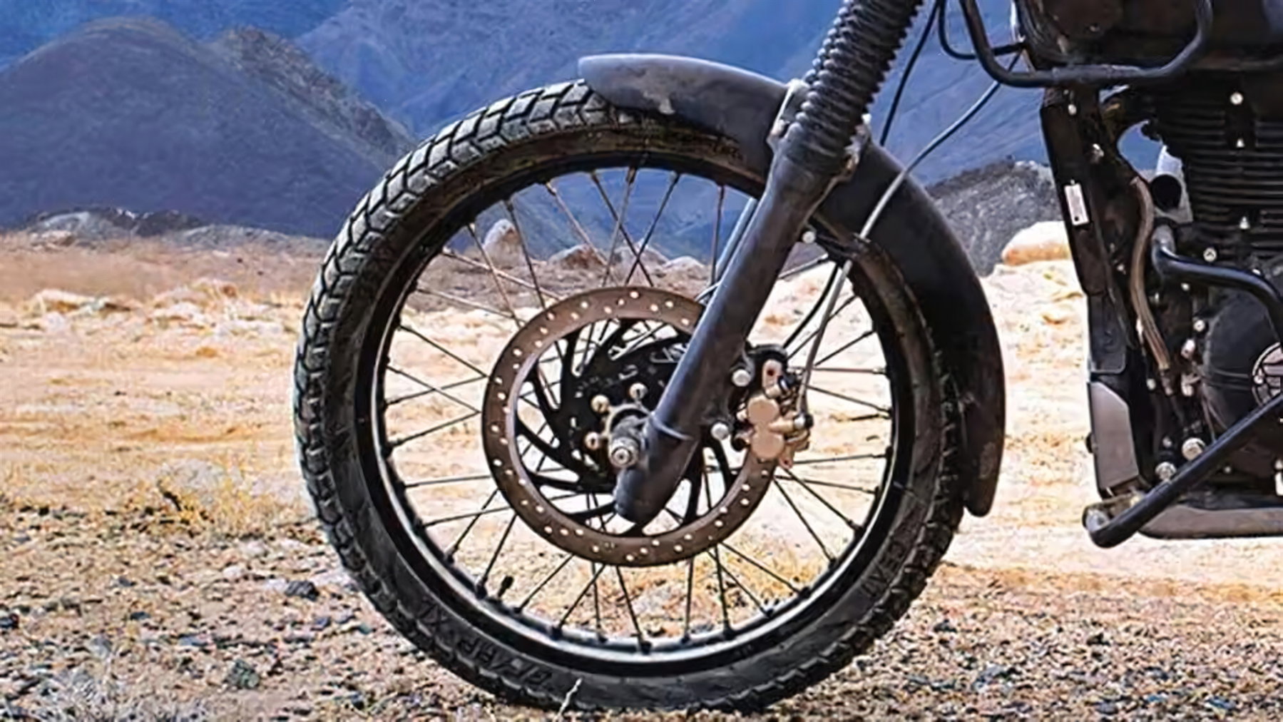 Royal Enfield Himalayan 440: the air-cooled 411 returns in September 3 Detailansicht des Vorderrads mit Speichenfelge und Bremsscheibe vor Bergpanorama