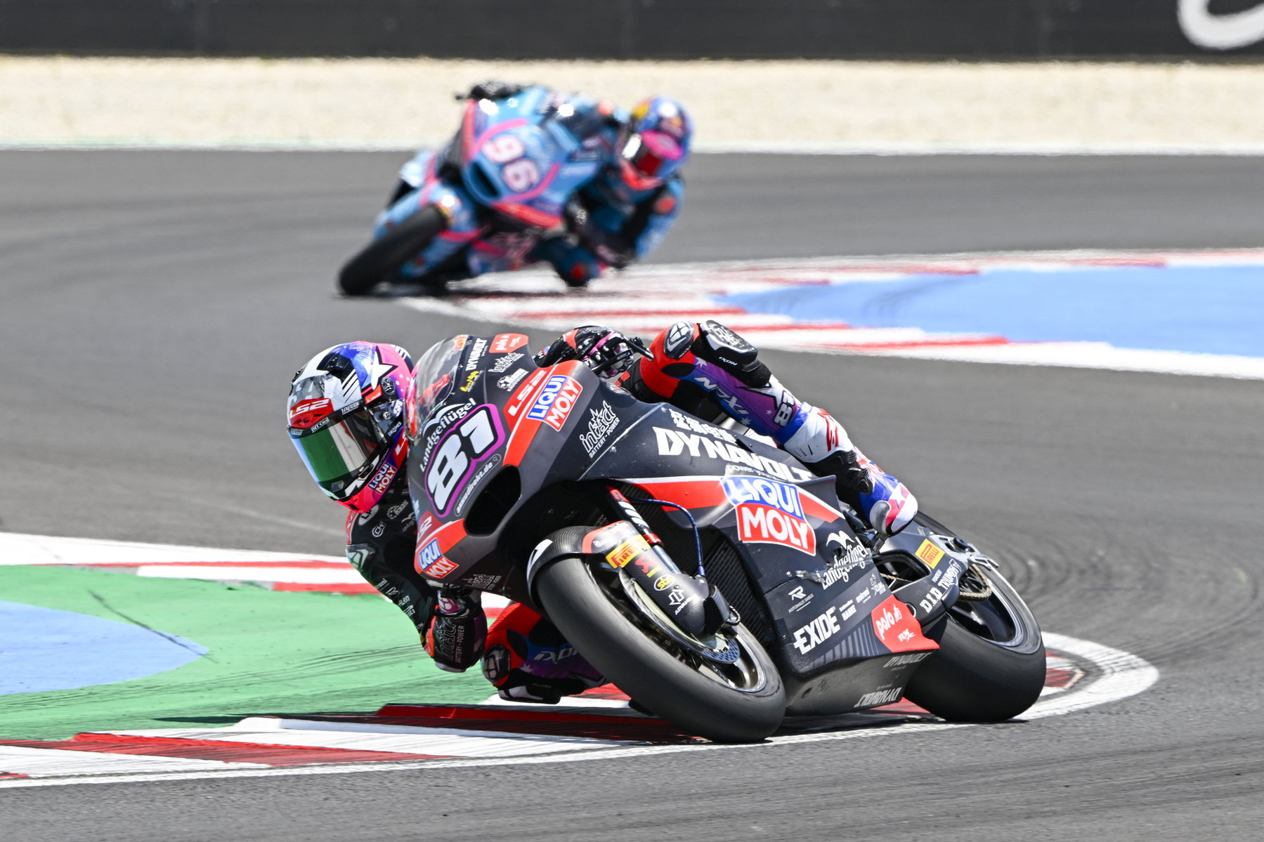 Triumph Moto2 Engine 2027: More Power Forces New Chassis 2 Senna Agius auf seiner schwarz-roten Moto2-Maschine mit Startnummer 81 in tiefer Schräglage beim Ungarn-Grand-Prix 2026, verfolgt von der blau-pinken Maschine mit Startnummer 96 – angetrieben vom Triumph 765-cm³-Dreizylinder
