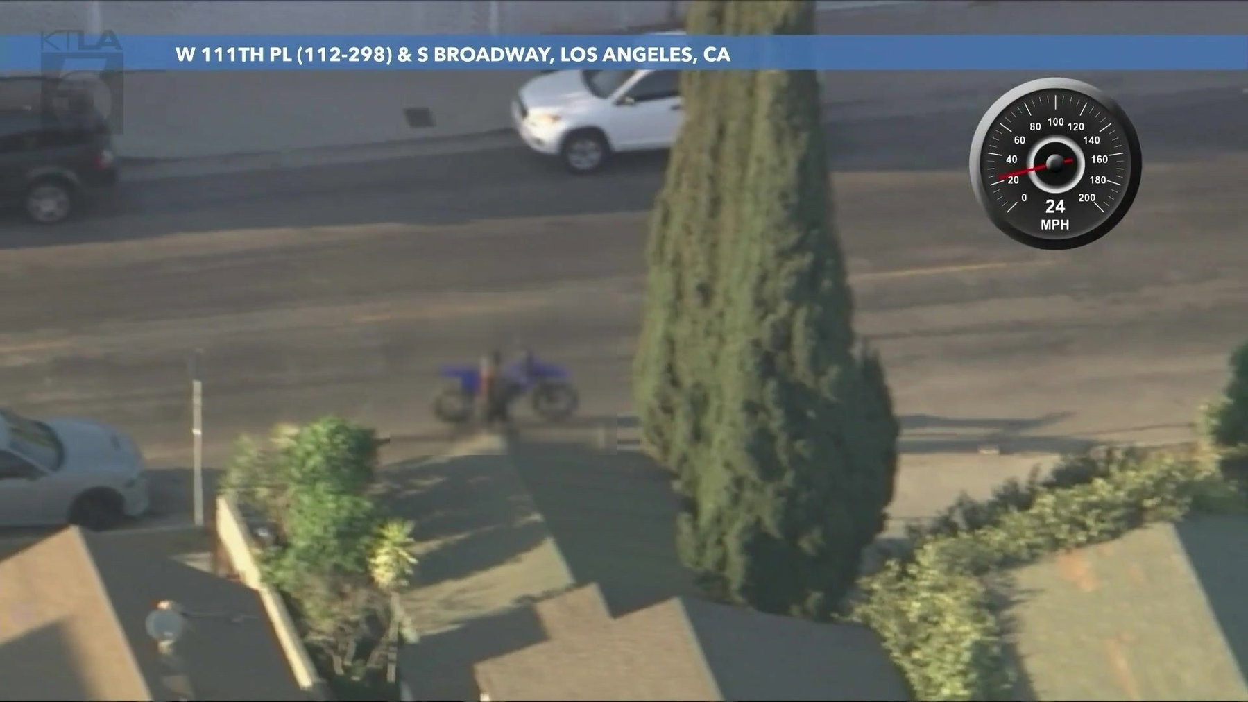 Dirtbike-Verfolgungsjagd in Los Angeles: Am Ende fehlte die Waffe 4 Luftaufnahme einer ruhigen Wohnstraße in Los Angeles mit parkenden Autos, ein Fahrer haelt mit dem Dirtbike am Straßenrand, die Person ist durch Verpixelung unkenntlich gemacht