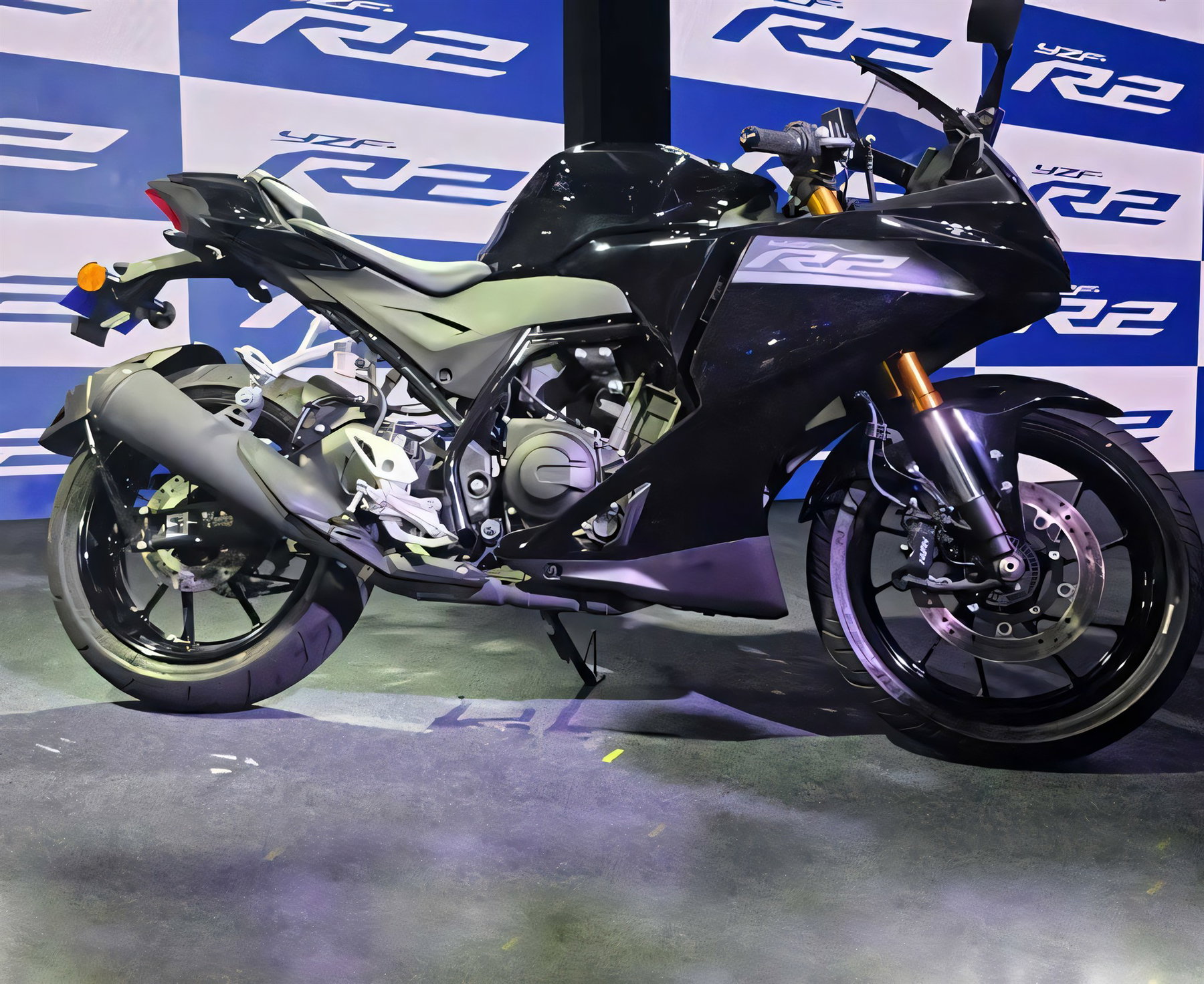 Yamaha R2 startet in Indien: Was das für den Europa-Markt bedeutet 6 Yamaha YZF-R2 in Schwarz auf der Buehne der Indien-Premiere, Seitenansicht vor beleuchtetem YZF-R2-Messestand