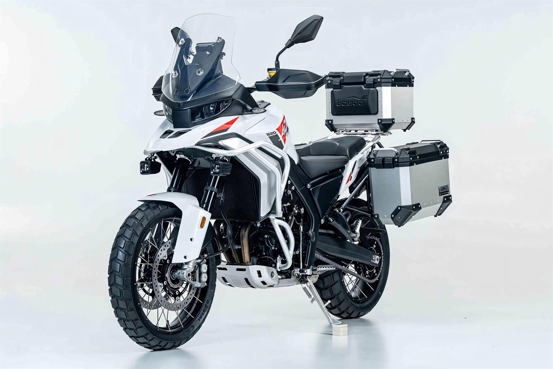 ZXMoto 820X mit Alu-Seitenkoffern und Topcase, Studioaufnahme von schraeg vorn mit Blick auf Kuehler, Dreizylindermotor, Speichenraeder mit grobstolligen Reifen und Motorschutzplatte