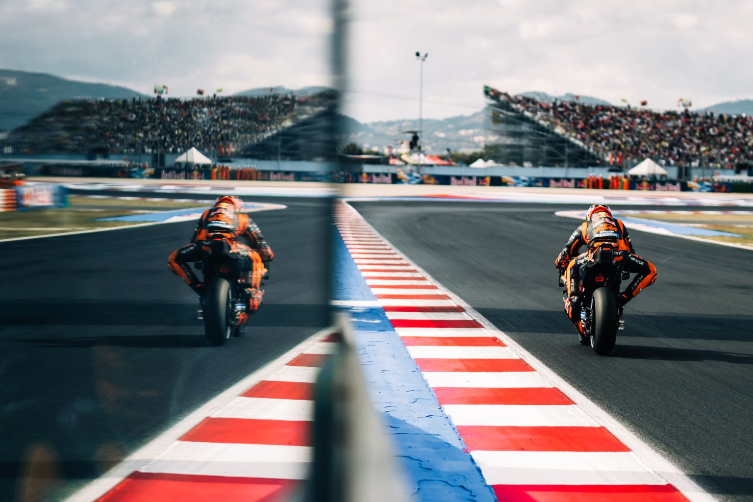 Zwei Red-Bull-KTM-Fahrer auf der Strecke von Misano, aufgenommen durch die Scheibe der Boxenmauer – MotoGP San-Marino-GP 2026