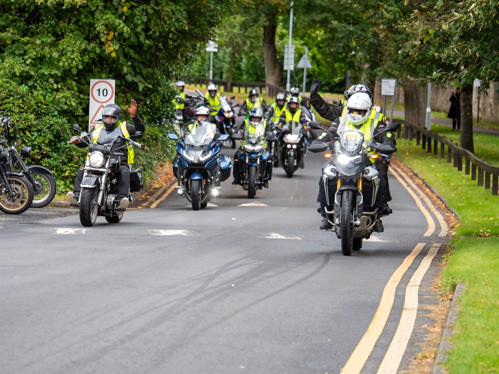 Beatson Bikers 2026: Wie aus 250 Bikern in drei Jahren 1300 wurden 3 Beatson Bikers – Kolonne aus Tourern und Reiseenduros in Warnwesten auf einer baumgesäumten Straße bei Glasgow
