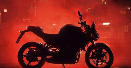 BMW F 450 R – Silhouette des neuen A2-Naked-Bikes in Seitenansicht vor rot beleuchtetem Nebel in einer nächtlichen Stadtkulisse, erkennbar sind Tankbuckel, USD-Gabel, Einzelscheibe vorn und Fünfspeichen-Räder