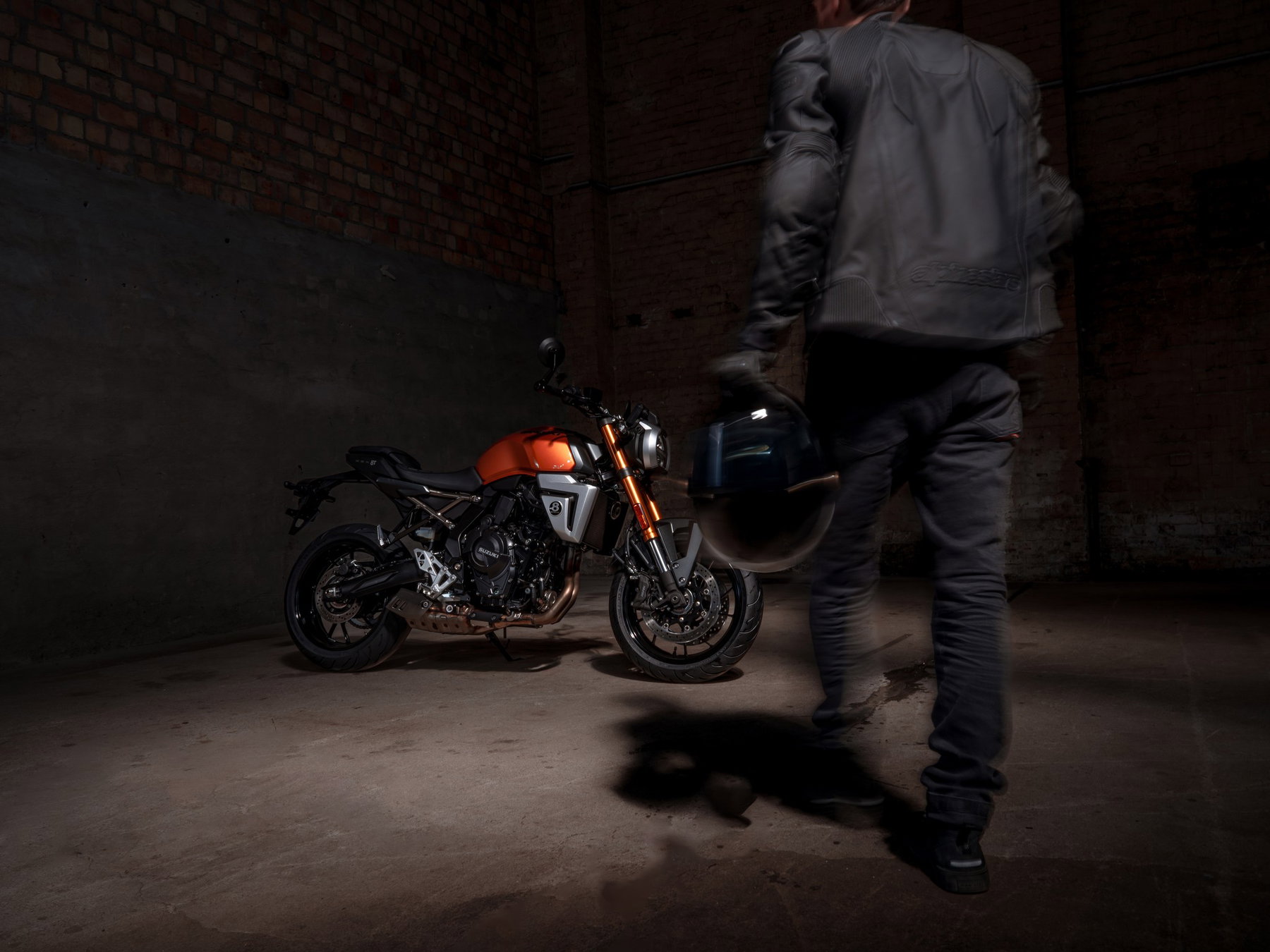 Continental ContiMotion EVO: New Tyre, but Not for Every Size 5 Continental ContiMotion EVO 2026 – Fahrer mit Helm in der Hand geht an geparktem Naked Bike vorbei, dunkle Industriehalle