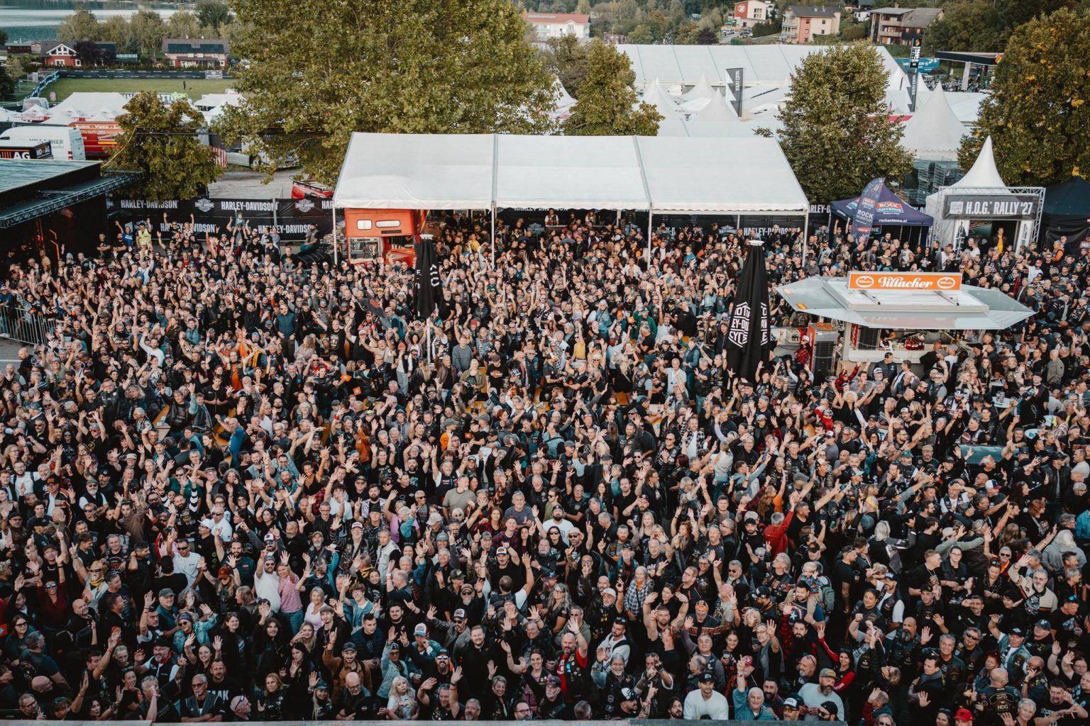 European Bike Week 2026: What Remains of the Harley Rally at Lake Faak European Bike Week 2026 – Luftaufnahme tausender winkender Besucher vor Harley-Davidson-Bühnenzelt und H.O.G. Rally Stand am Faaker See