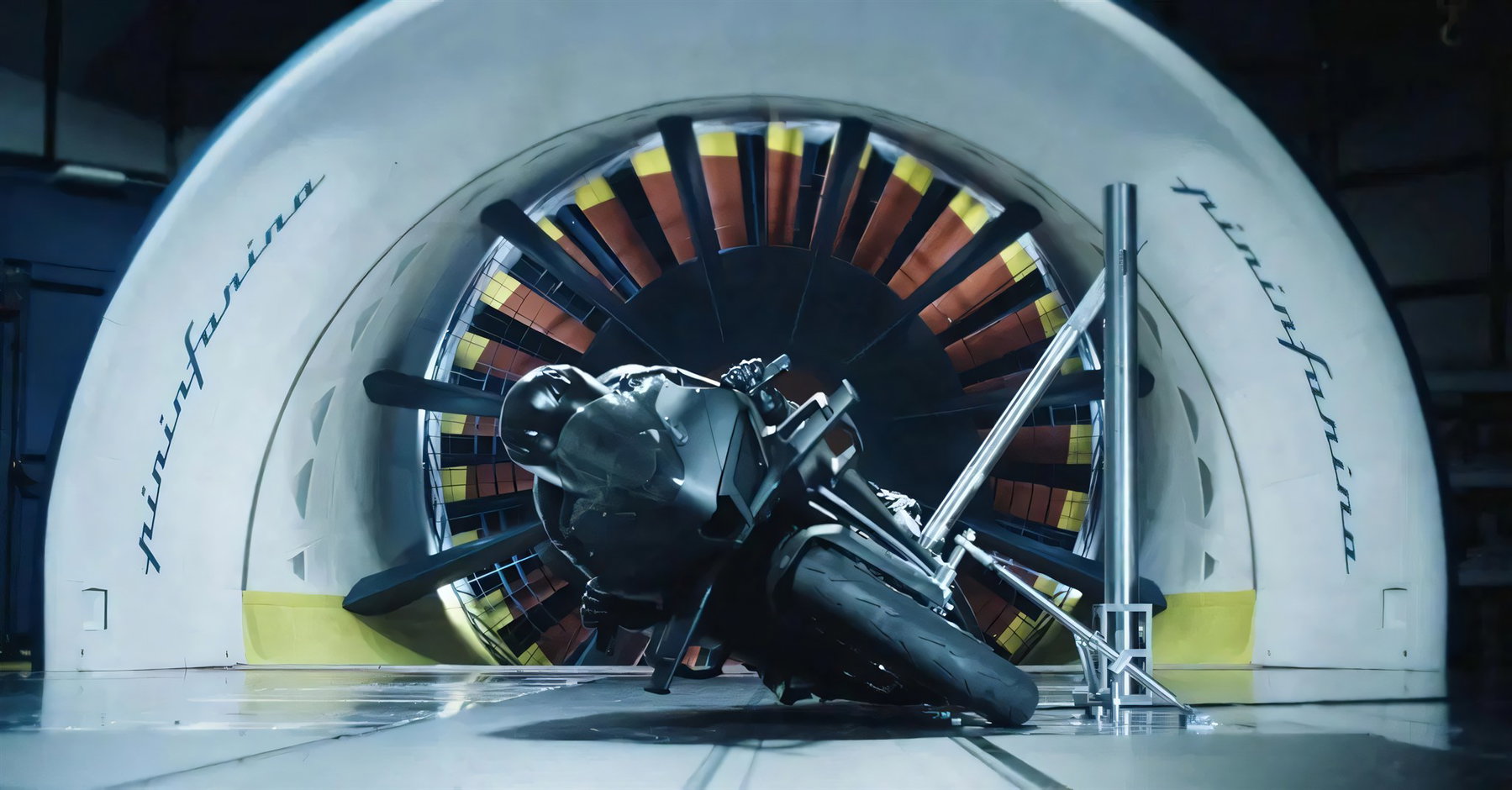 Modena40 wird 10: Warum CFMOTOs Zukunft in Italien entsteht 5 CFMOTO V4 SR-RR Prototyp mit Test-Dummy im Windkanal von Pininfarina, sichtbarer Luefterrotor und Pininfarina-Schriftzug an der Tunnelwand