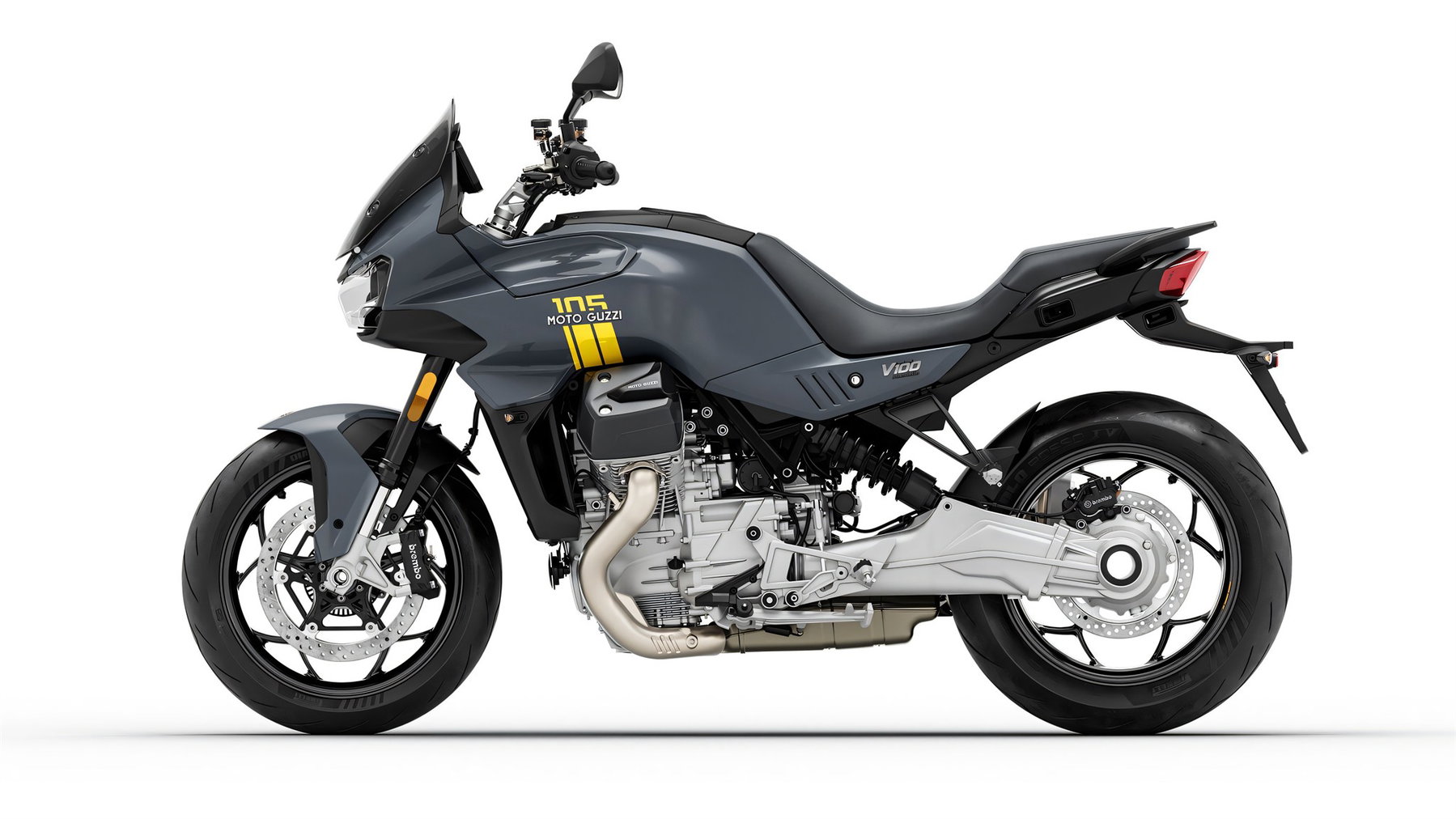 Moto Guzzi 105th Anniversary Edition: Fünf Modelle tragen die Farben des neuen Werks 1 Moto Guzzi V100 Mandello 105th Anniversary Edition – Seitenansicht in Perlglanz-Grau mit gelber 105-Jubiläumsgrafik am Tank, Studioaufnahme vor weißem Hintergrund