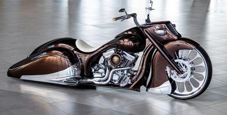 Slow Burn: How Game Over Cycles Turned a 1936 Auburn Into a Bagger Slow Burn Bagger von Game Over Cycles in Seitenansicht im Studio, dunkles Kupfer-Braun-Metallic mit schwarzen Verlaufsakzenten, weißer Ledersattel, verchromtes Harley-V2-Triebwerk und großes Chrom-Speichen-Vorderrad