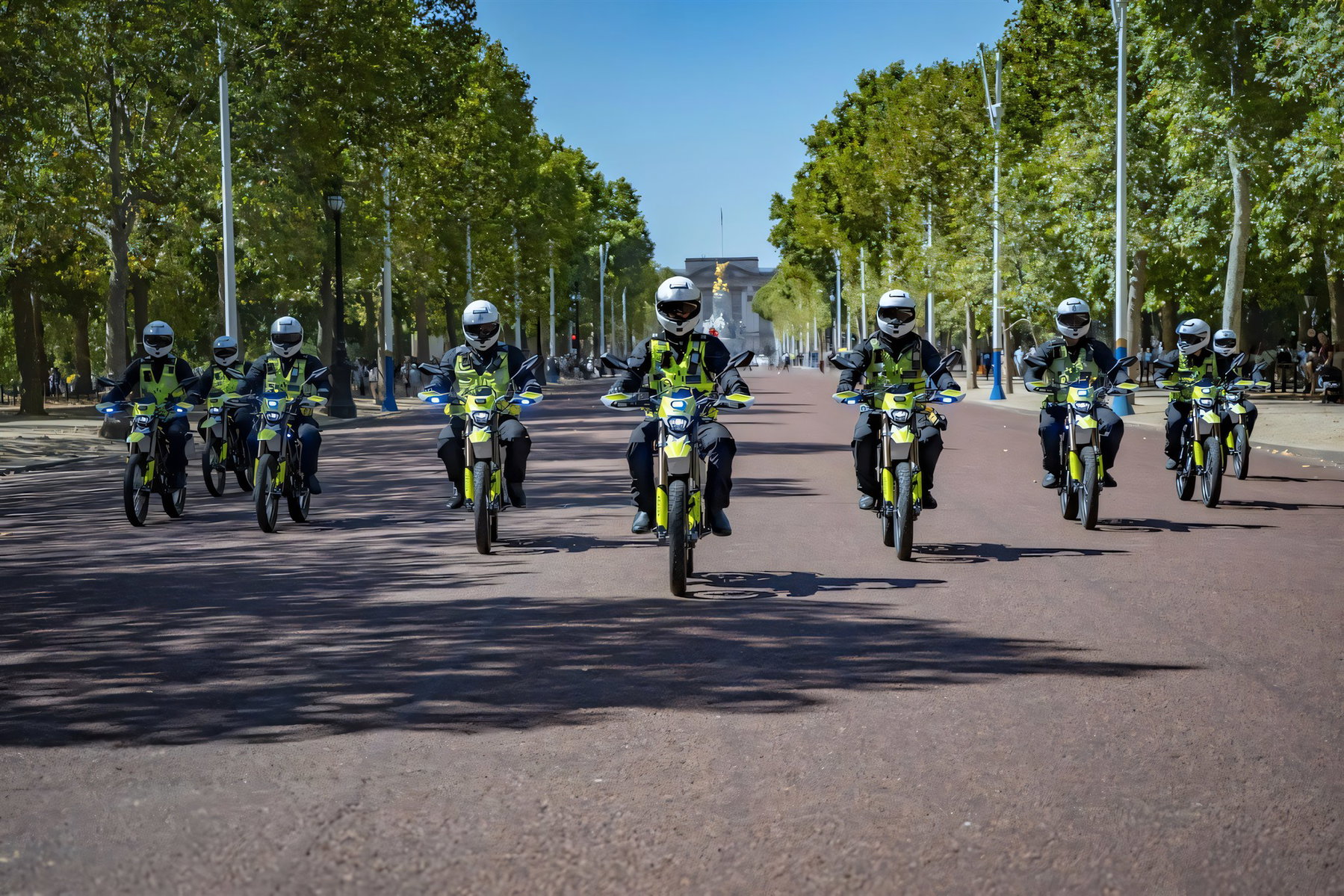 London Police Ride the Sur-Ron Ultra Bee: 25 Bikes Against Phone Snatching 5 Metropolitan-Police-Beamte auf Sur-Ron-Ultra-Bee-Polizeimotorraedern fahren in Formation auf The Mall Richtung Buckingham Palace, das im Hintergrund zu sehen ist