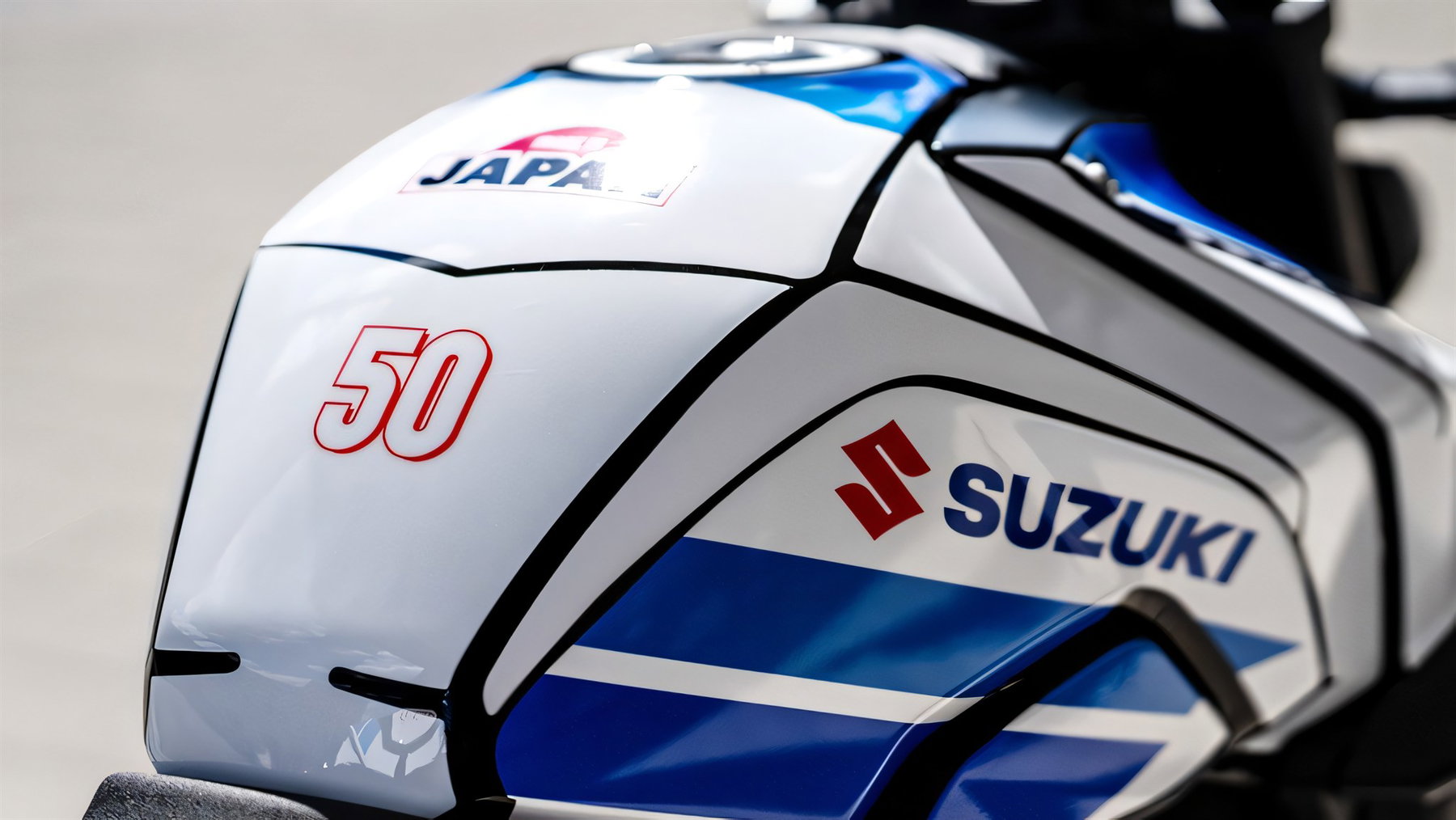 Suzuki GSX-8S and GSX-S1000 Special Edition: Just 50 Units Each 4 Suzuki GSX-8S Special Edition 2026 – Tankdetail des Dekor-Kits mit blauem Suzuki-Schriftzug, roter Jubiläumszahl 50 und Made-in-Japan-Emblem