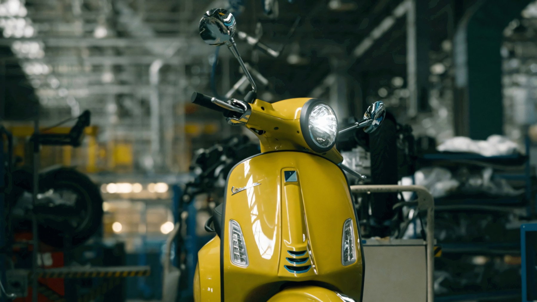 Vespa Primavera wird zur EU-Marke: Was das für Retro-Roller bedeutet 1 Gelbe Vespa Primavera in der Frontansicht mit Rundscheinwerfer und Beinschild in der Produktionshalle