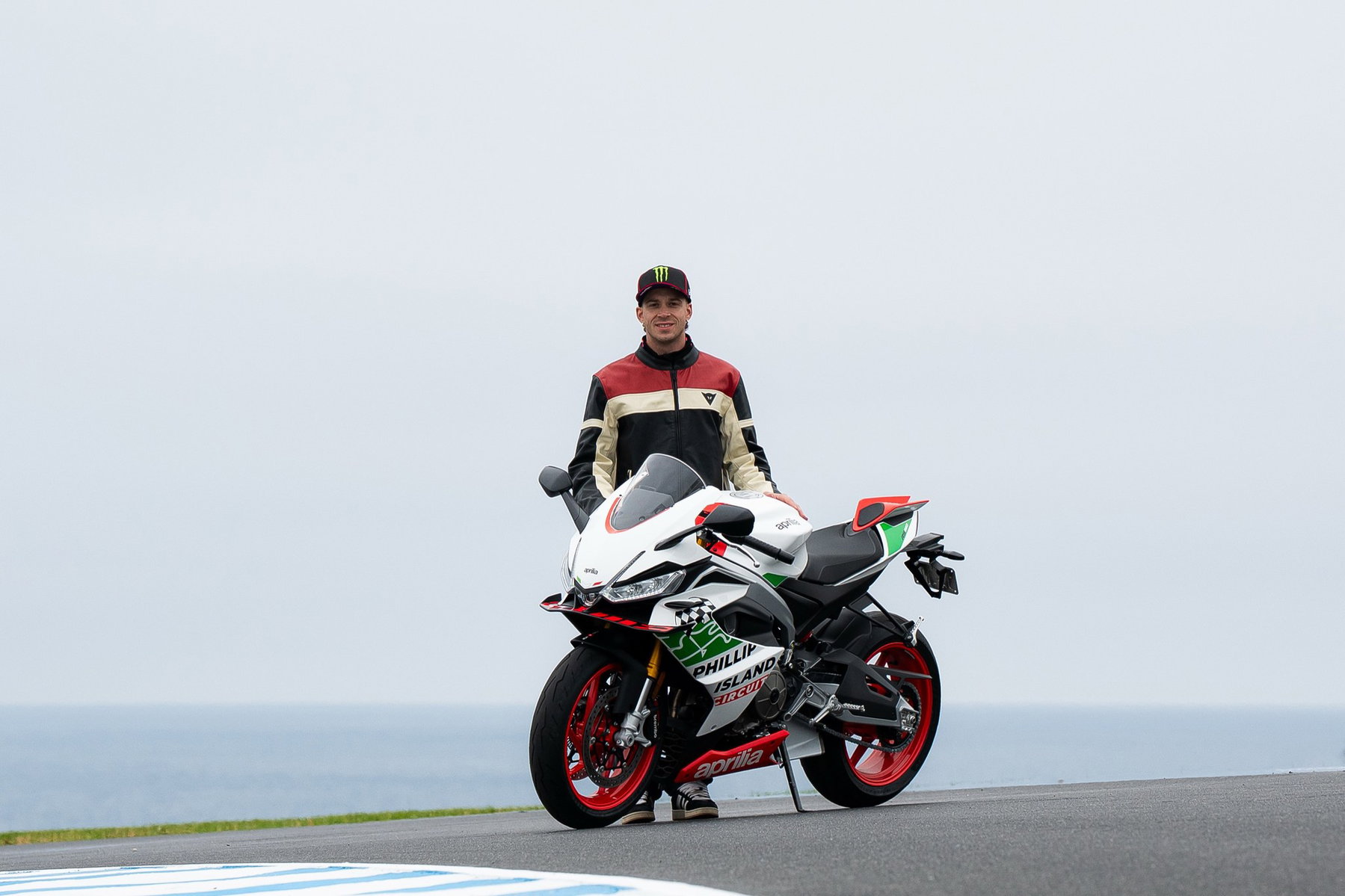 RS 660 Phillip Island Tribute: Aprilias Sondermodell zum MotoGP-Abschied 5 Marco Bezzecchi steht hinter der Aprilia RS 660 Phillip Island Tribute auf der Rennstrecke von Phillip Island